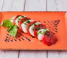 Моцералла с помидорами и соусом из базилика