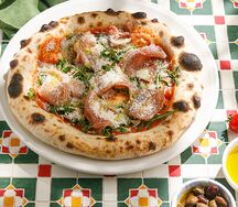 Пицца с пармской ветчиной, рукколой и пармезаном