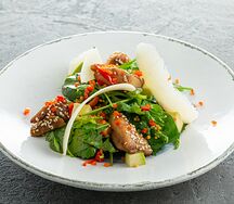 Теплый салат с куриным бедром, свежими овощами и сыром пармезан