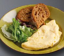 Омлет из двух яиц с тостами и листьями салата