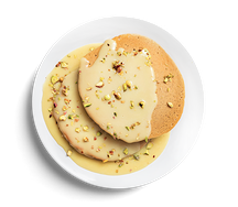 Банановые панкейки с соусом из белого шоколада и фисташками