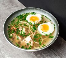 Насыщенный куриный бульон с яйцом, лапшой и зеленью