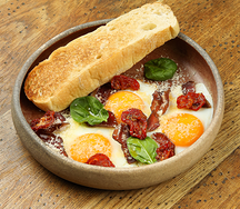 Яичница из трех яиц с фирменным вяленым мясом, вялеными томатами и пармезаном