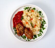 Мясные котлеты под грузинским соусом с рисом и овощами