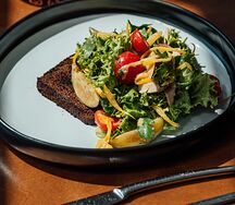 Салат с томленой курицей и свежей сливой на хрустящем бородинском хлебе