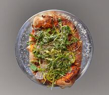 Пицца с копченной грудинкой свинины, рукколой и трюфельным маслом