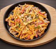 Сковородка с жареной свининой и овощами в сливках