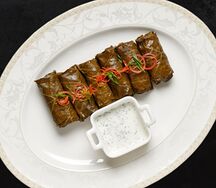 Долма в винoградных листьях с гранатом и соусом мацони