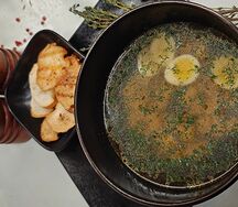 Куриный бульон с перепелиным яйцом, зеленью и пряными гренками