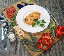 Свиная отбивная под овощами и сыром с гарниром на выбор