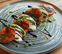 Розовые томаты с моцареллой и соусом песто