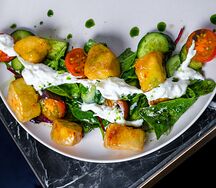 Салат с хрустящими баклажанами, свежими овощами и страчателлой