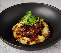 Голень теленка с картофельным пюре, цукини и соусом из черноплодки