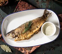 Форель фаршированная свежей зеленью со сванскими специями и сливочным соусом
