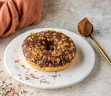 Донат с карамельной начинкой и посыпкой