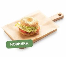 Бейгл с жареным беконом, свежим салатом и томатами