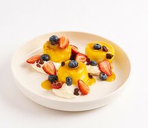 Сырники в апельсиновом соусе со сливочным кремом и свежими ягодами