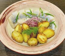 Сельдь пряного посола с картофелем, красным луком и брусникой