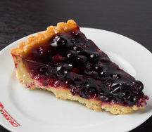 Кусок открытого пирога с черной смородиной