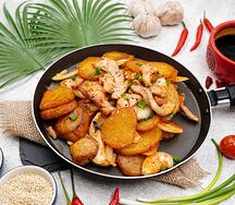 Острая курица с картофелем и луком на горячей сковороде