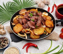 Острые куриные желудки с картофелем на горячей сковороде