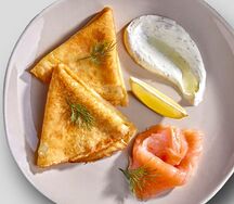 Блины с лососем с соусом из сметаны и свежего укропа.