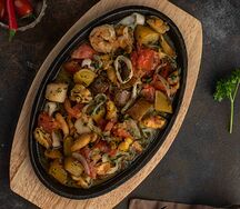 Сковородка с морепродуктами, картофелем и томатами