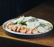 Тигровые креветки с листьями салата Романо и соусом Цезарь