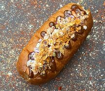 Хот-дог с соусом из черного перца и колбаской барбекю с сыром в беконе