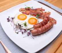 Яичница глазунья с жареным беконом и сосисками гриль