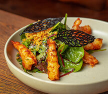 Салат с креветками Тандори, маслянистым авокадо, сладкими томатами черри и черным хрустящим хворостом