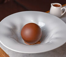 Шоколадная сфера с фисташковым пралине, муссом из трюфеля, мороженым из сливочного печенья и горячим домашним шоколадом