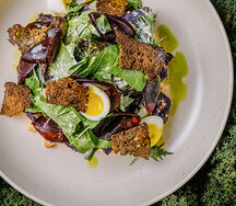 Салат с копченой форелью, мягким перепелиным яйцом и трюфельным соусом