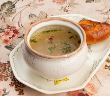 Уха волжская на петухе, сготовленная должным образом, с сомом, судаком, водкой и брусникой с расстегаем подаваемая