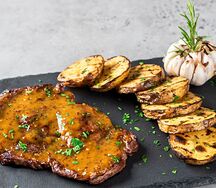 Свиной стейк с соусом и картофелем