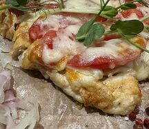 Куриная отбивная под сырной шапкой с томатами и маринованным луком