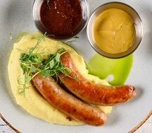 Немецкие колбаски с картофельным пюре, соусом Нью-Йорк и горчицей
