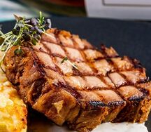 Стейк из свиной шеи с печеным картофелем и сырным соусом