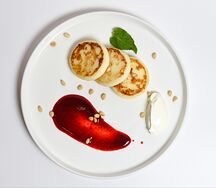 Сырники с брусничным соусом и сметаной