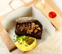 Бефстроганов с телятиной и грибами в хлебной тарелке с картофельным пюре