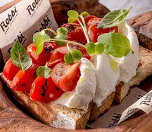 Две брускетты со сливочным сыром, медом и томатами