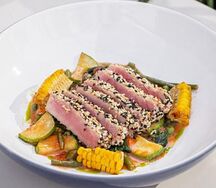 Стейк из тунца в кунжутной панировке с овощами по-средиземноморски