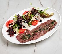 Тальята из оленины с микс-салатом, помидорами и грана падано