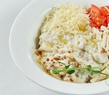 Каша с пармезаном, куриным филе, соусом цезарь и томатами