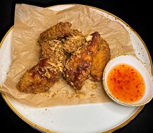 Куриные крылья с карамелизированным луком и острым соусом