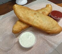 Пять жаренных пирожков с капустой и два соуса