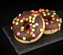 Донат в шоколадной глазури с драже