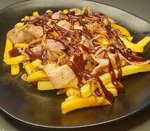 Картофель фри с беконом и жареным луком в соусе барбекю