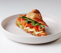 Круассан с лососем и листьями салата