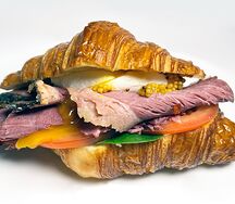 Круассан с яйцом пашот, пастрами из говядины, сливочным сыром, свежим шпинатом и томатами